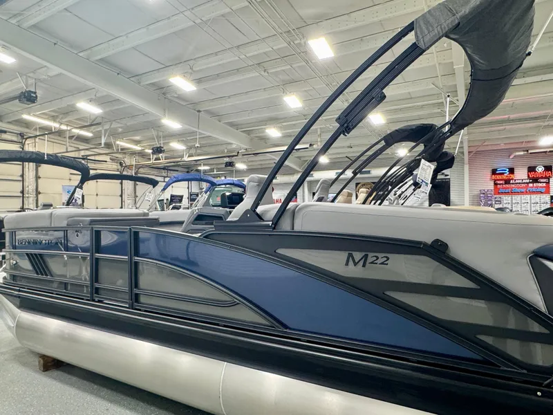 Slide: The Image of 2025 Bennington M Quad Bench 22 MFB pontoon boat displayed indoors. - 4