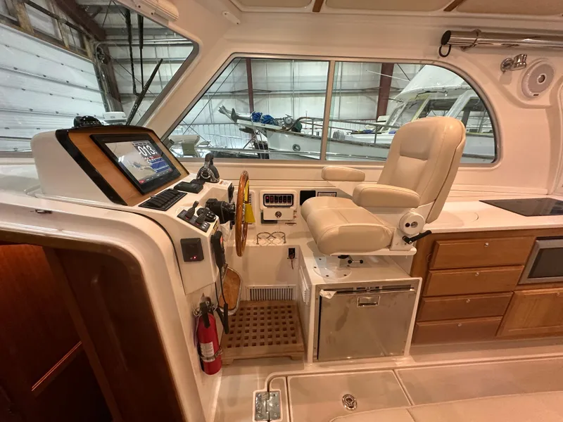 Slide: The Image of 2018 Back Cove 32 boat interior with helm, captain's chair, and navigation equipment. - 10