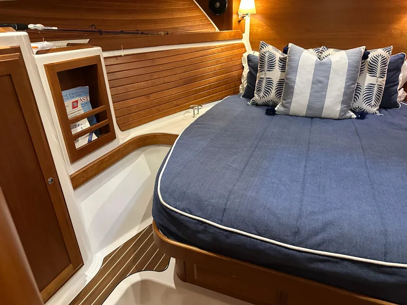 Slide: The Image of Cozy cabin interior of 2018 Back Cove 32 with blue bedding and wooden accents. - 15