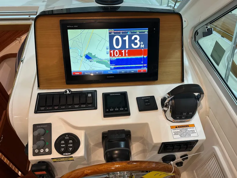 Slide: The Image of 2018 Back Cove 32 helm with navigation display and control panel. - 18