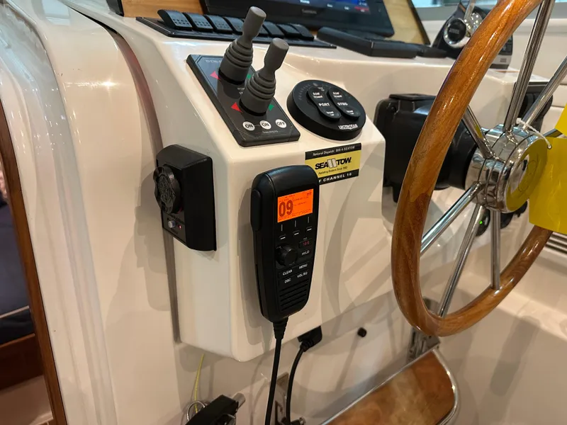 Slide: The Image of Control panel of a 2018 Back Cove 32 boat with steering wheel and communication device. - 19