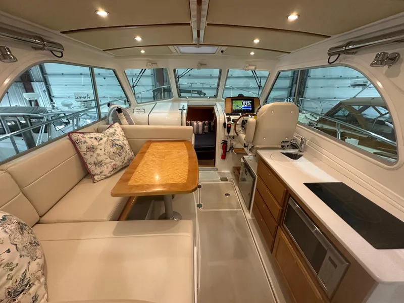 Slide: The Image of 2018 Back Cove 32 yacht interior with seating, table, and modern kitchen amenities. - 2