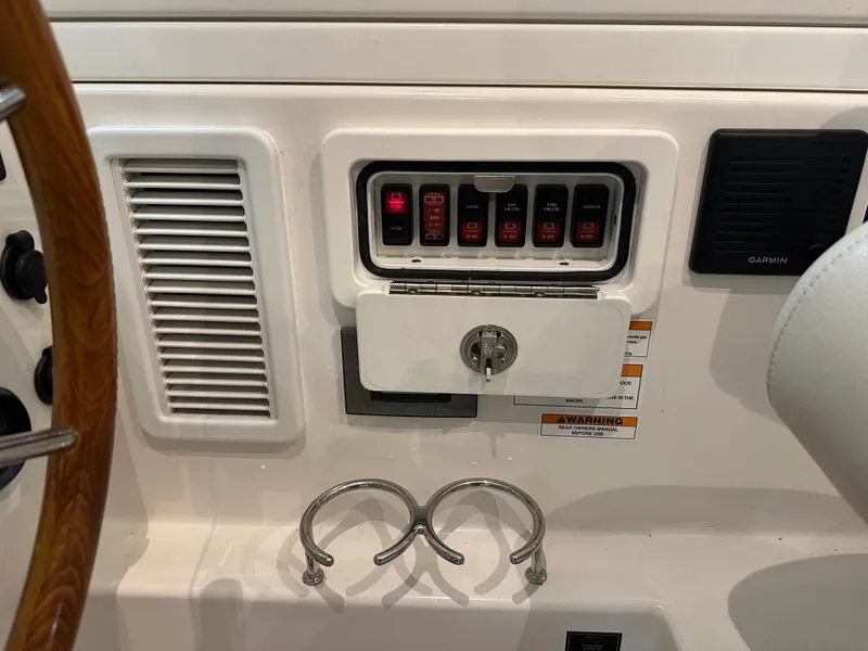 Slide: The Image of Control panel of a 2018 Back Cove 32 boat with switches and cup holders. - 20