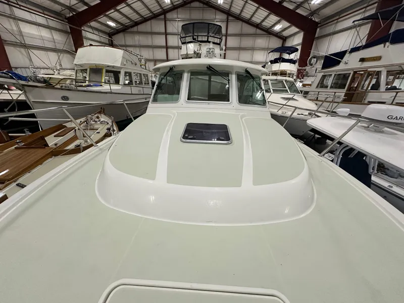 Slide: The Image of 2018 Back Cove 32 boat in indoor storage, surrounded by other vessels. - 26