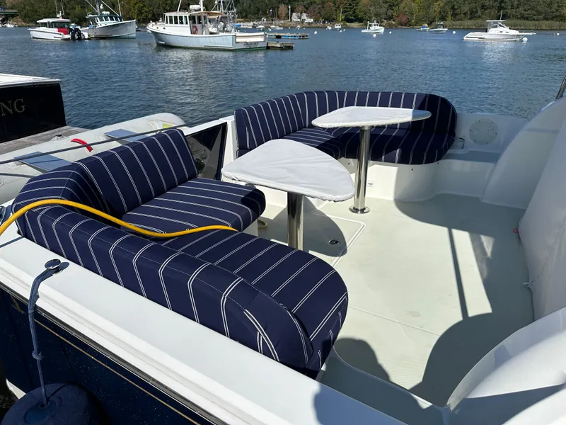 Slide: The Image of 2018 Back Cove 32 boat with striped seating, docked on a calm lake. - 28
