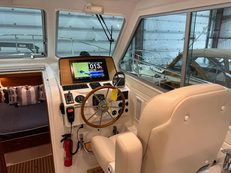 Slide: The Image of 2018 Back Cove 32 boat interior with helm, navigation display, and seating. - 5
