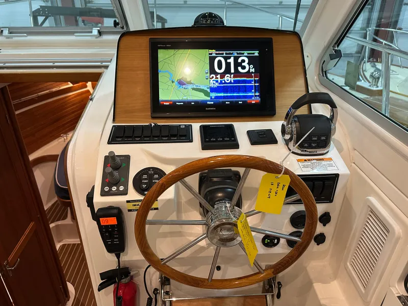 Slide: The Image of 2018 Back Cove 32 helm with navigation display and wooden steering wheel. - 7