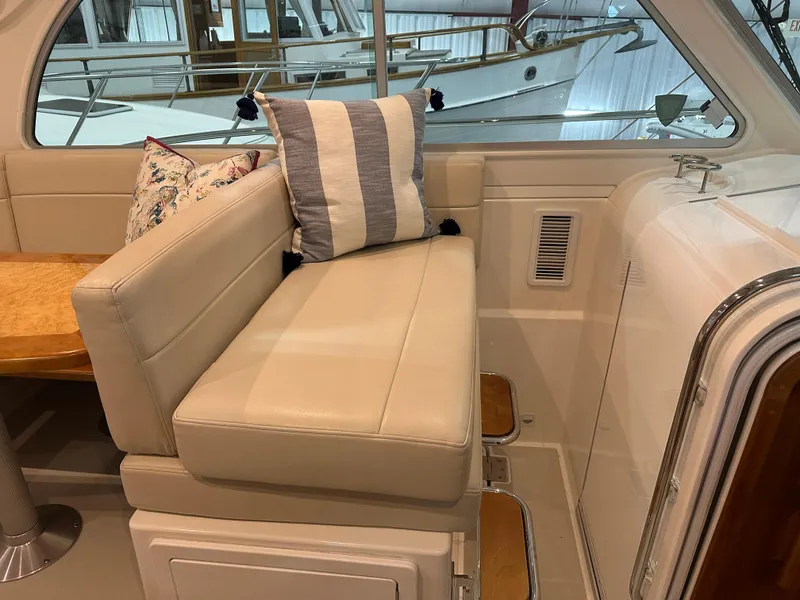 Slide: The Image of 2018 Back Cove 32 interior with beige seating and striped cushions. - 8
