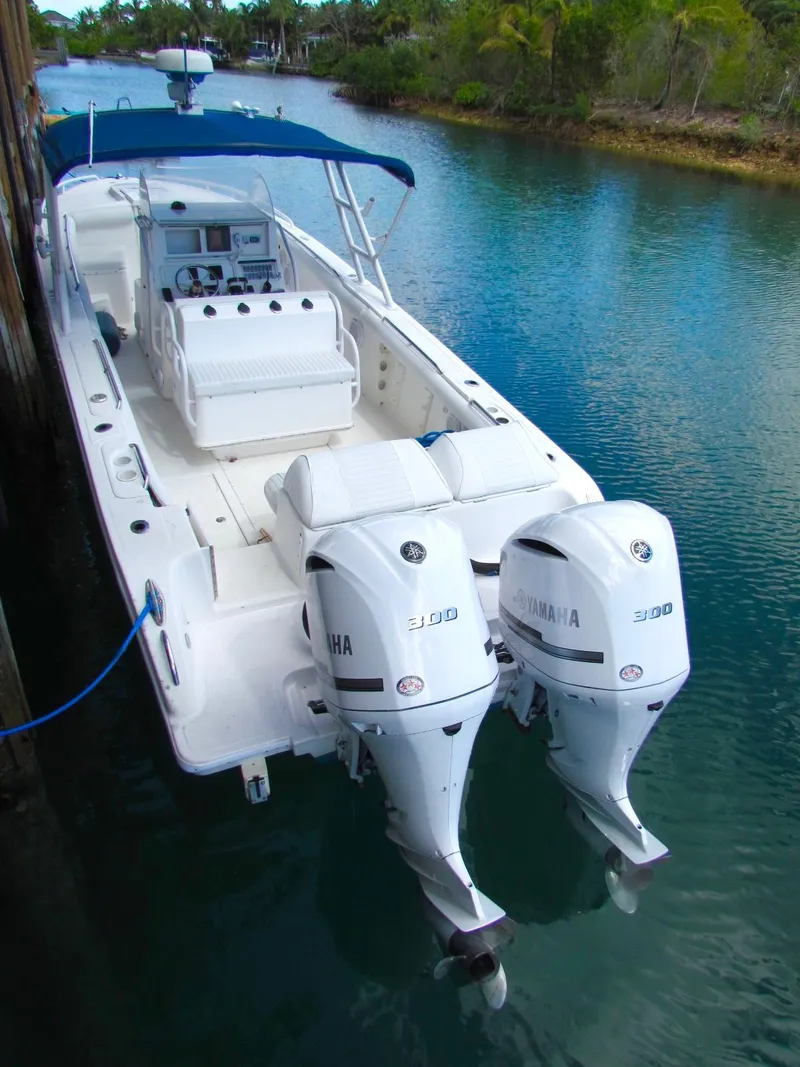 Slide: The Image of 2005 Marlago F35 boat with twin Yamaha engines docked in a serene waterway. - 10