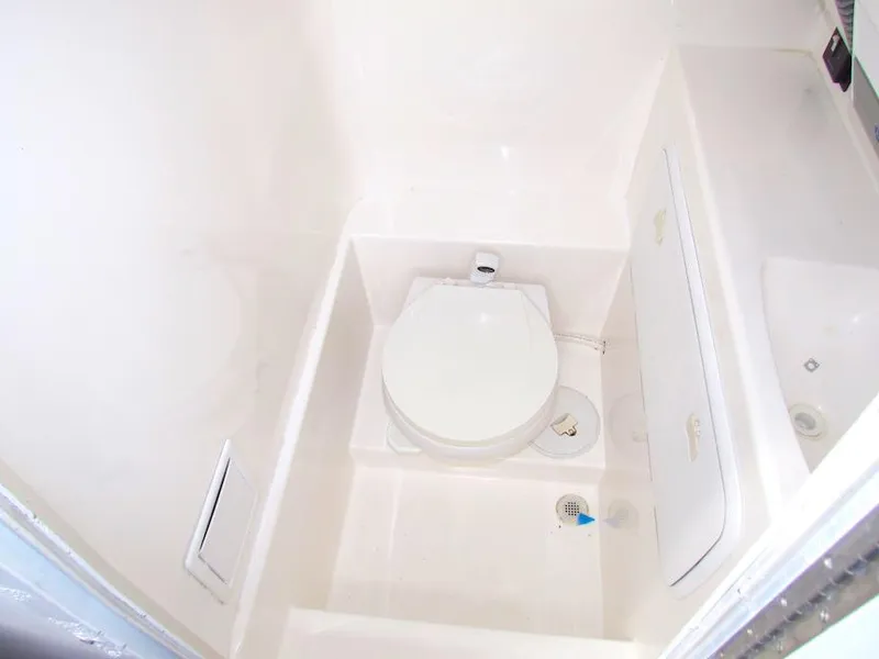 Slide: The Image of Compact bathroom in a 2005 Marlago F35 boat, featuring a white marine toilet. - 13
