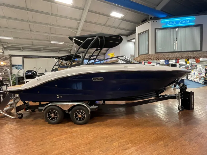 Slide: The Image of 2025 Sea Ray SPX 210 boat on trailer in showroom, featuring sleek design and modern amenities. - 1
