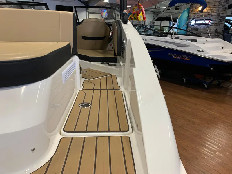 Slide: The Image of 2025 Sea Ray SPX 210 boat interior with tan seating and wood-style flooring. - 4