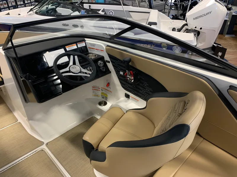 Slide: The Image of 2025 Sea Ray SPX 210 boat interior with steering wheel and beige seating. - 7