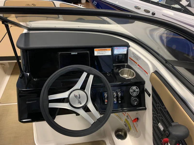 Slide: The Image of 2025 Sea Ray SPX 210 boat dashboard with steering wheel and control panel. - 9