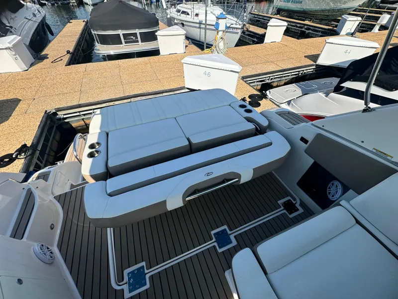 Slide: The Image of 2016 Regal 32 Express boat interior with cushioned seating at a marina. - 11