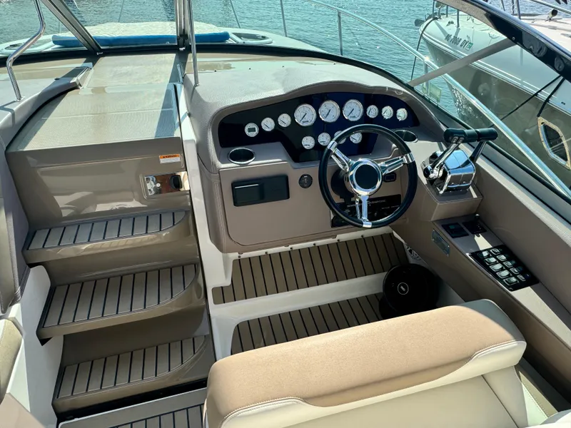 Slide: The Image of 2016 Regal 32 Express boat helm with steering wheel and control panel. - 13
