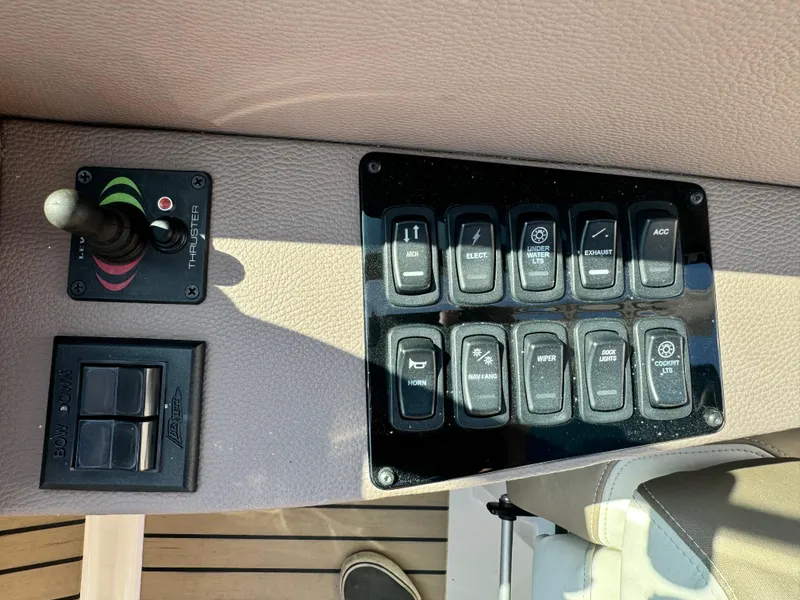 Slide: The Image of Control panel of a 2016 Regal 32 Express boat with various switches and thruster joystick. - 16