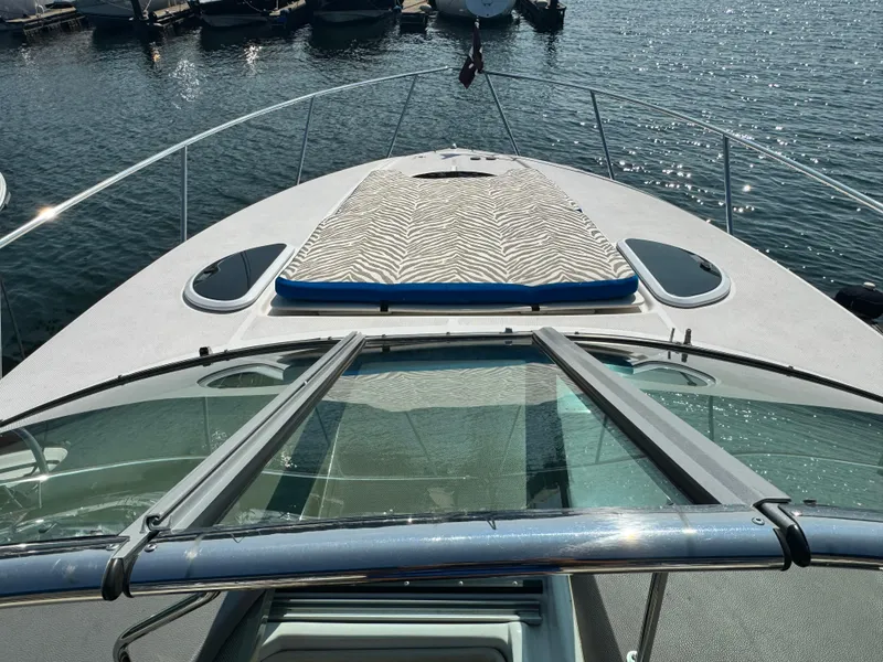 Slide: The Image of 2016 Regal 32 Express boat with zebra-patterned sun pad on deck, docked by the water. - 19