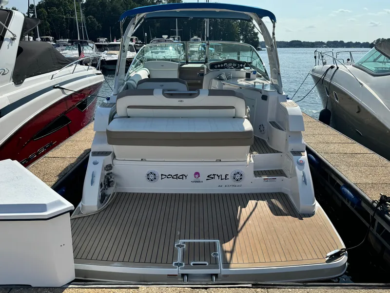 Slide: The Image of 2016 Regal 32 Express boat docked at marina, rear view with seating area. - 2