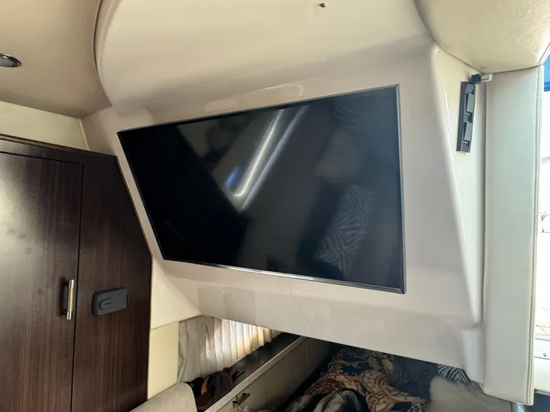 Slide: The Image of Interior of 2016 Regal 32 Express with mounted flat-screen TV and wooden cabinet. - 26