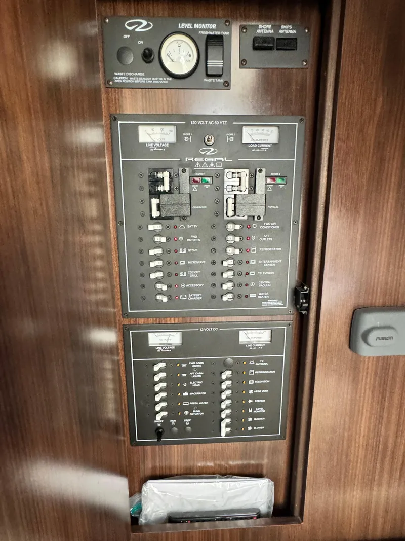 Slide: The Image of Electrical control panel on a 2016 Regal 32 Express boat, featuring switches and gauges. - 27