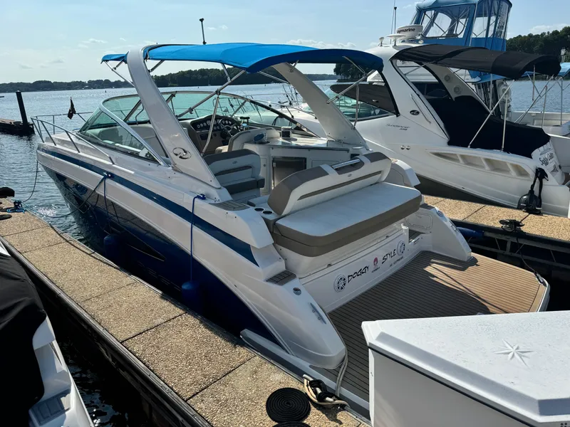 Slide: The Image of 2016 Regal 32 Express boat docked, featuring a blue canopy and spacious seating area. - 3