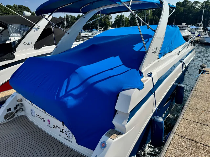 Slide: The Image of 2016 Regal 32 Express boat with blue cover docked at marina. - 30