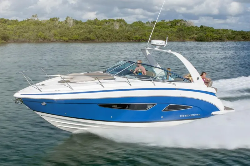 Slide: The Image of 2016 Regal 32 Express boat cruising on water with passengers, featuring a sleek blue and white design. - 31