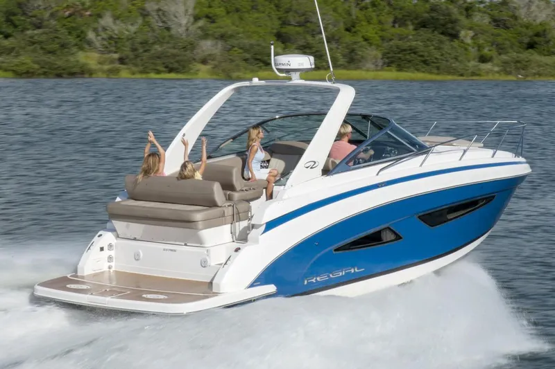Slide: The Image of 2016 Regal 32 Express boat cruising on a lake with passengers enjoying the ride. - 32