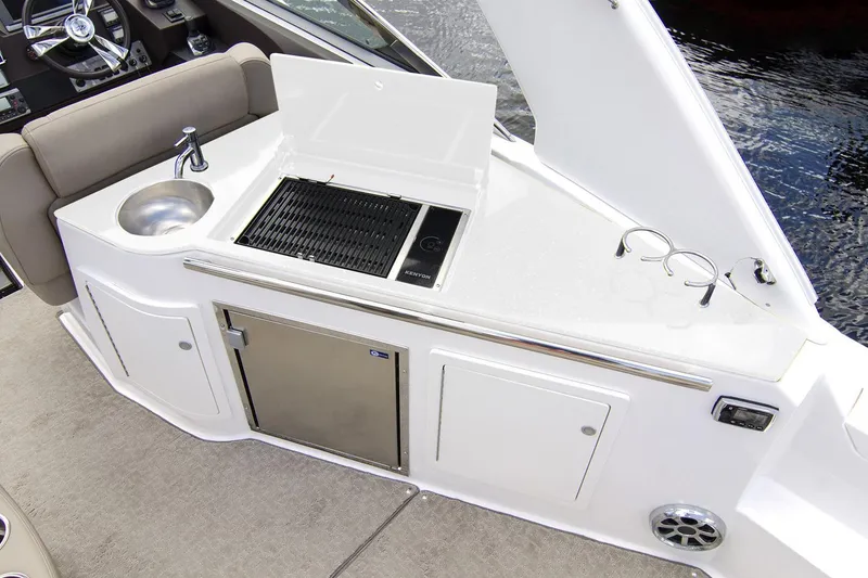 Slide: The Image of 2016 Regal 32 Express boat kitchenette with sink, grill, and storage. - 36