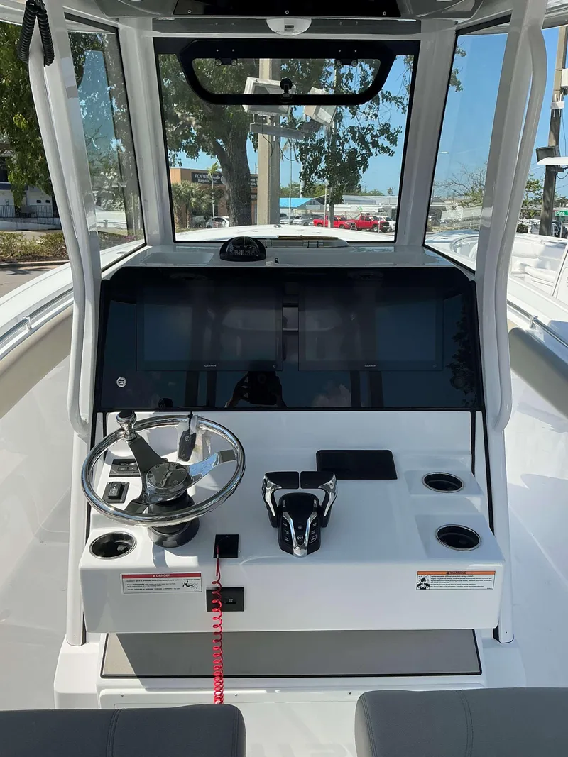 Slide: The Image of 2025 Sportsman 282 Open boat dashboard with steering wheel and controls. - 14