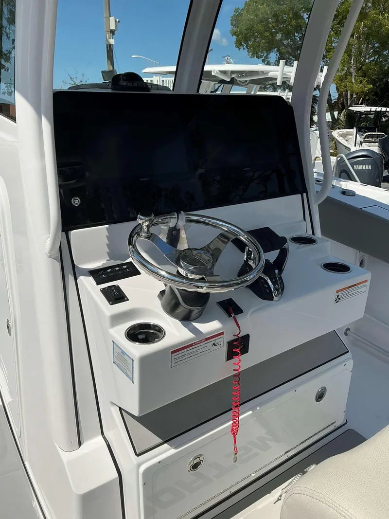 Slide: The Image of 2025 Sportsman 282 Open boat helm with steering wheel and control panel. - 16