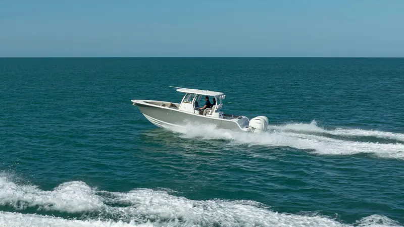Slide: The Image of 2025 Sportsman 282 Open boat cruising on open sea under clear blue sky. - 2