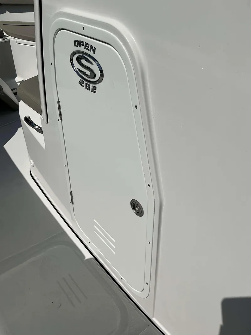 Slide: The Image of 2025 Sportsman 282 Open boat compartment door with logo in sunlight. - 23