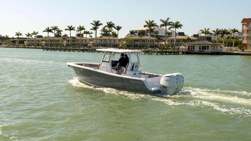 Slide: The Image of 2025 Sportsman 282 Open boat cruising near waterfront homes and palm trees. - 3