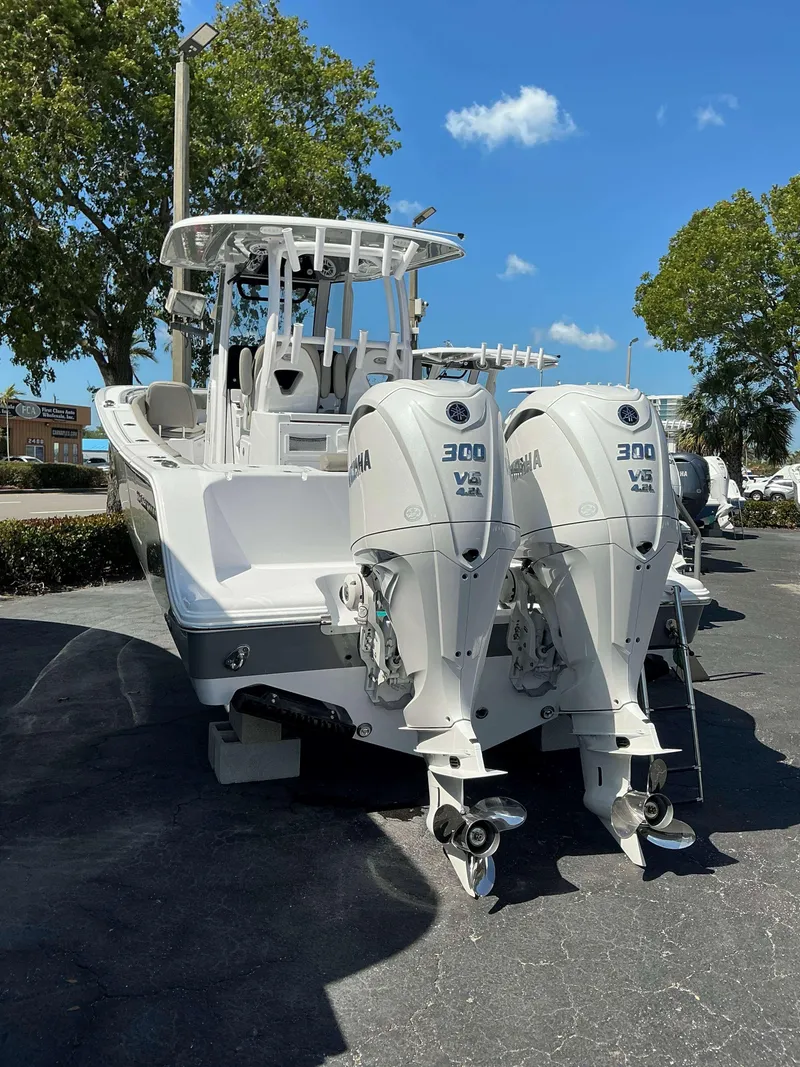 Slide: The Image of 2025 Sportsman 282 Open boat with dual Yamaha 300 engines, parked outdoors. - 6