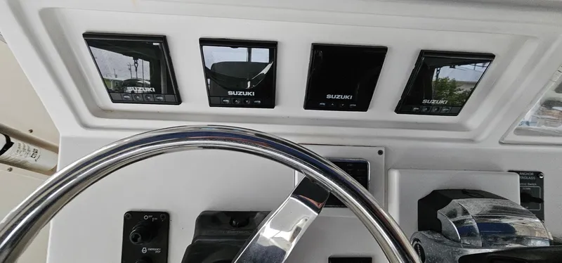 Slide: The Image of Control panel of 2003 Jefferson Marlago FS35 boat with Suzuki displays and steering wheel. - 10