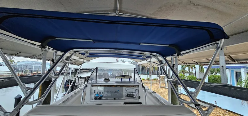 Slide: The Image of 2003 Jefferson Marlago FS35 boat with blue canopy docked at marina. - 13