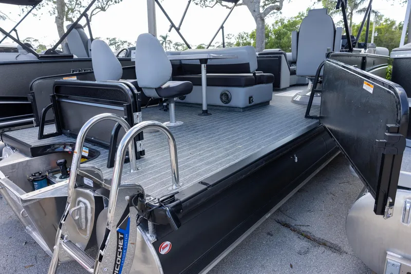 Slide: The Image of 2025 Premier 230 Sunsation RS pontoon boat with seating and ladder, docked outdoors. - 11