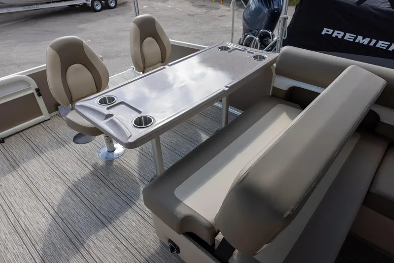 Slide: The Image of 2025 Premier 250 Sunsation RS boat interior with seating and table, featuring cup holders. - 15