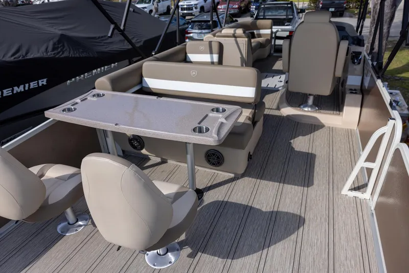 Slide: The Image of 2025 Premier 250 Sunsation RS pontoon boat interior with beige seating and table. - 3