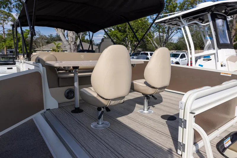 Slide: The Image of 2025 Premier 250 Sunsation RS pontoon boat interior with beige seating and canopy. - 5