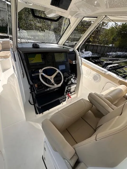 Slide: The Image of 2019 Pursuit S 328 Sport boat interior with steering wheel and navigation system. - 7