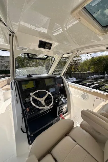 Slide: The Image of Interior view of 2019 Pursuit S 328 Sport boat cockpit with steering wheel and controls. - 8