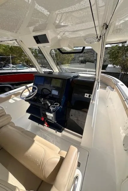 Slide: The Image of 2019 Pursuit S 328 Sport boat interior with steering console and seating. - 9