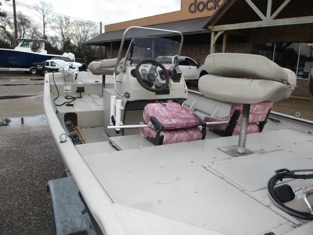 Slide: The Image of 2008 SeaArk X160 CC boat with cushioned seats and steering console, parked outdoors. - 2