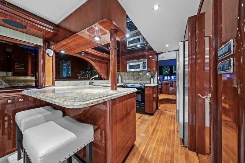 Slide: The Image of Luxurious 2006 Cheoy Lee Motor Yacht interior with elegant wood finishes and modern kitchen amenities. - 22