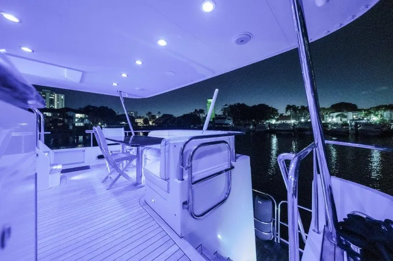 Slide: The Image of Luxurious 2006 Cheoy Lee motor yacht deck illuminated at night, featuring modern seating and ambient lighting. - 43