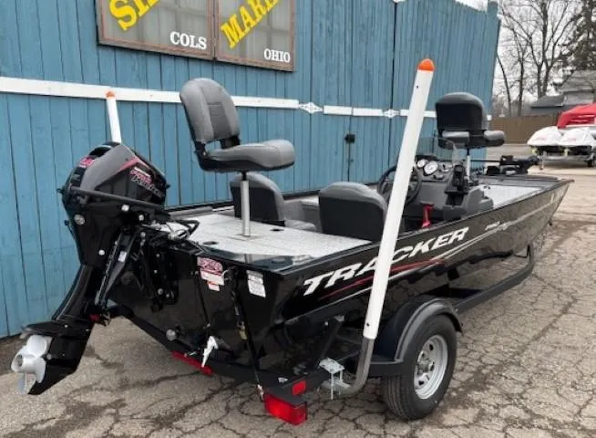 Slide: The Image of 2024 Tracker Pro 170 boat, black exterior, parked outdoors, featuring motor and seating. - 3