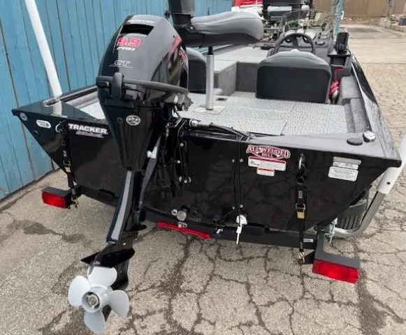 Slide: The Image of 2024 Tracker Pro 170 boat with outboard motor, parked on pavement. - 4